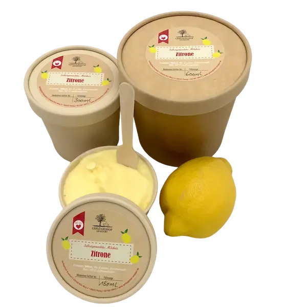 Frisches Zitroneneis im geöffneter Becher mit Holzlöffel und einer ganzen Zitrone vom Geflügelhof Arnsdorf bei Penig.